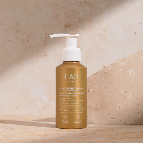 Crème Capillaire Régénérante bond repair LAO Care sans rinçage, flacon pompe doré sur pierre