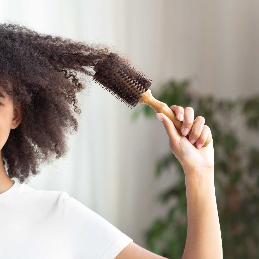 Femme qui se brosse les cheveux - LAO - Cheveux au naturel - Soins lavants 100% d'origine naturelle - Shampoings sans sulfates ni silicones